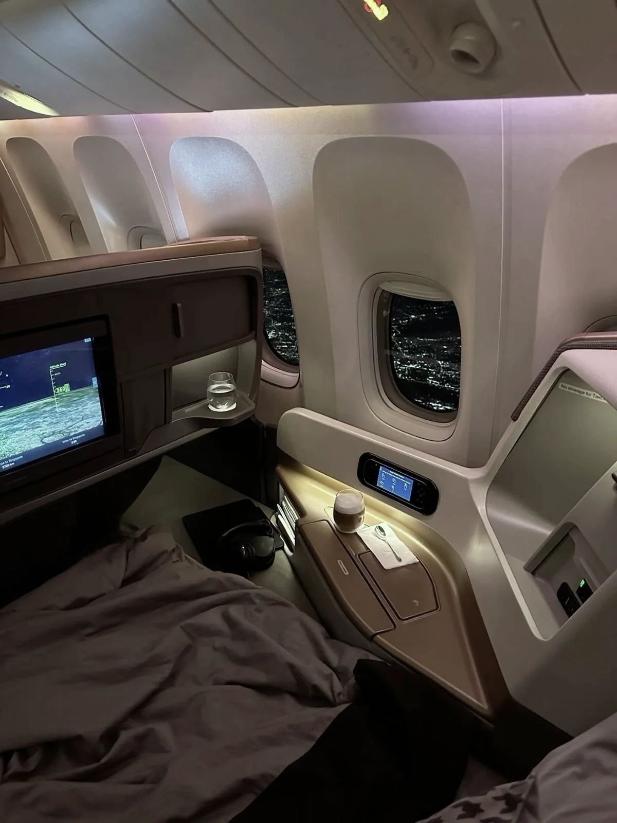 A Business Class suite beside the window at night
